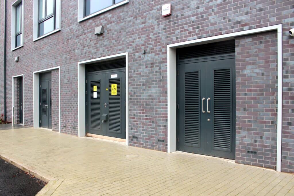 Modern building with double grey doors and brick facade