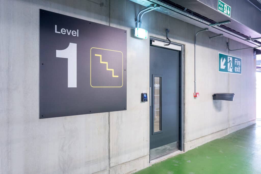 Level 1 sign with stair icon near fire exit door