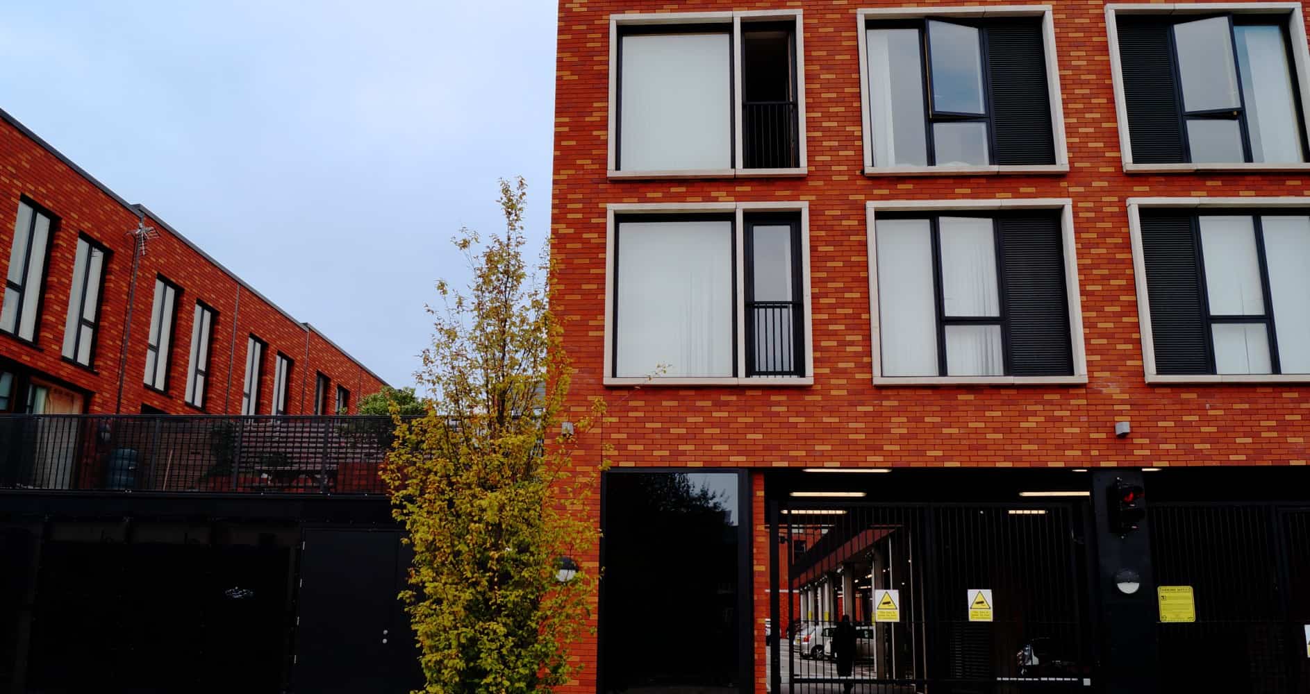 Modern red brick apartment building with large windows