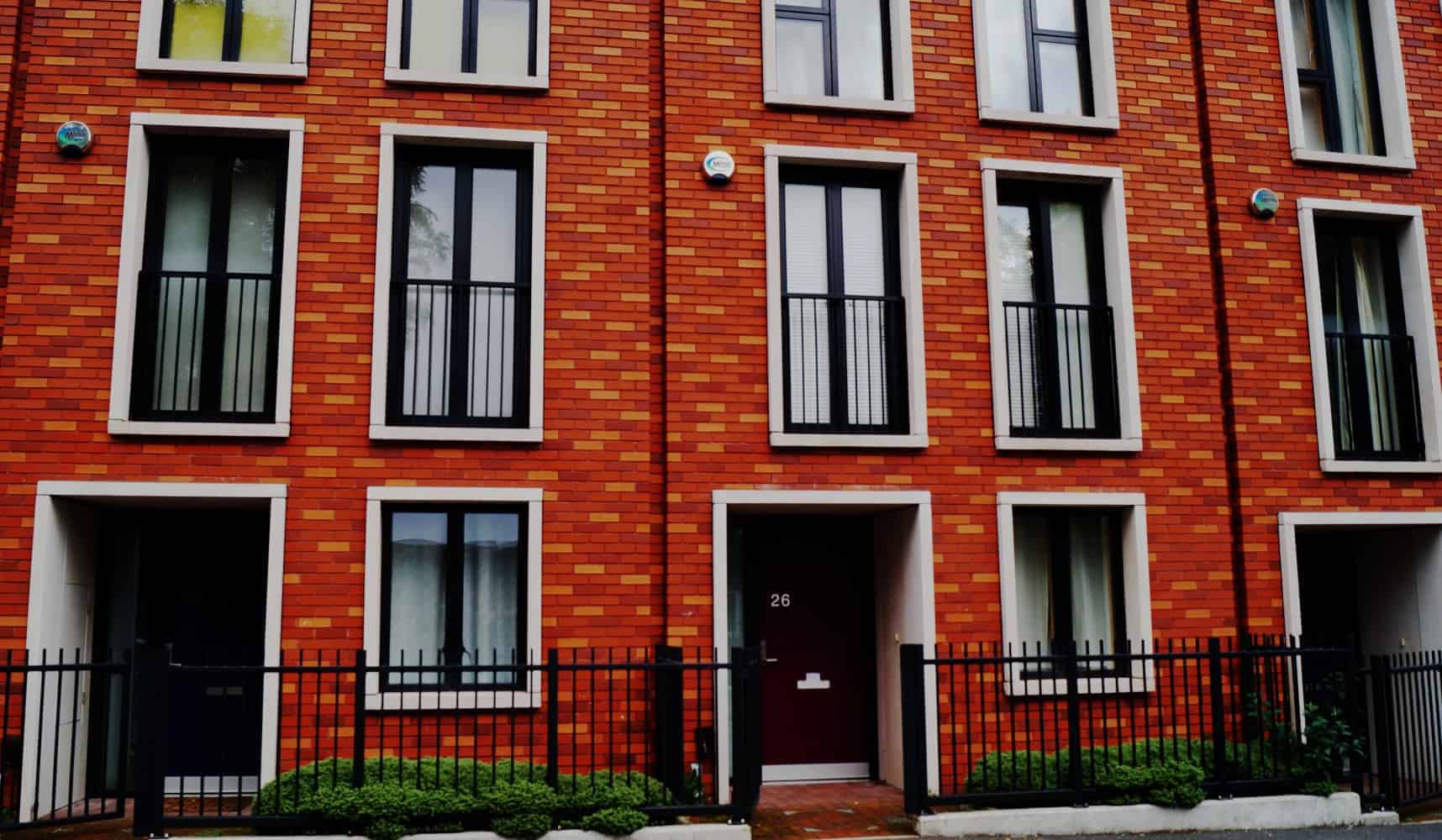 Modern red brick townhouse with black framed windows
