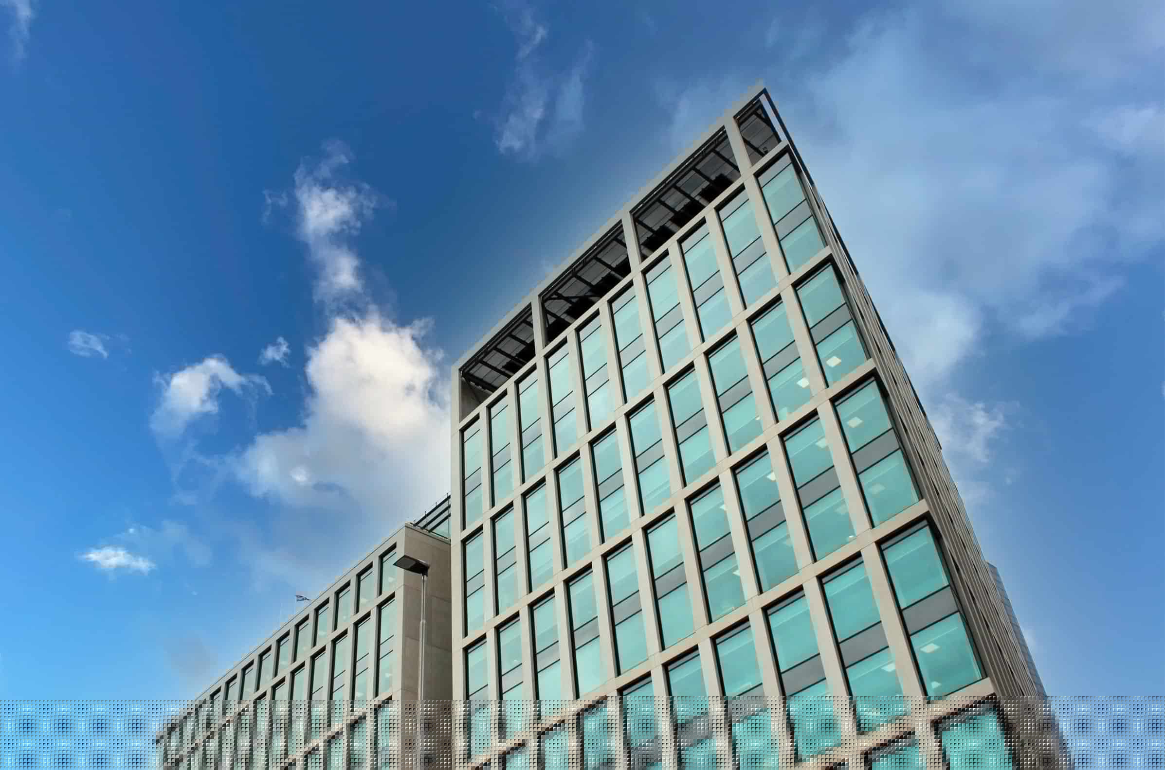 Modern glass office building against blue sky