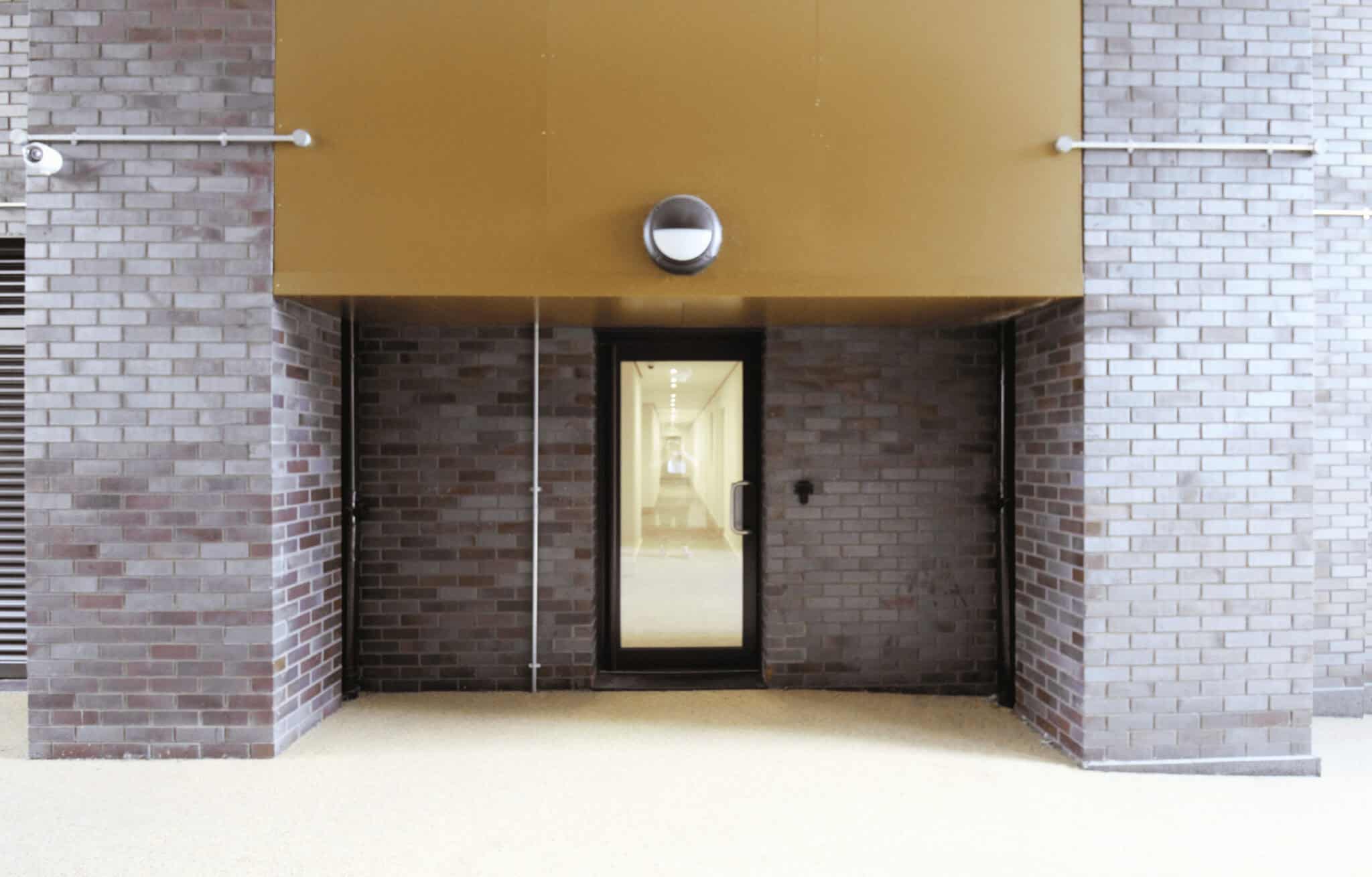 Glass door entrance with brick wall exterior