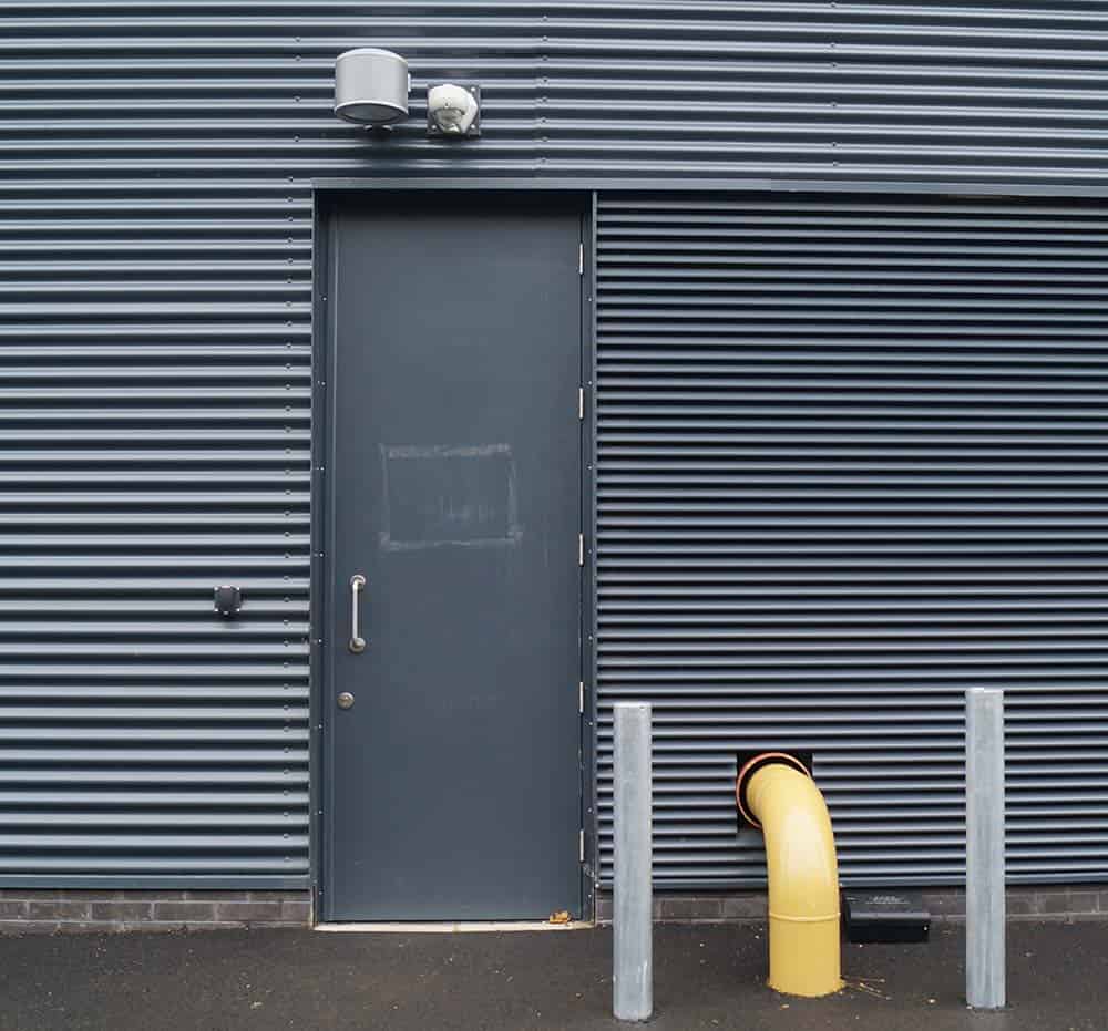 Grey metal door on corrugated industrial building