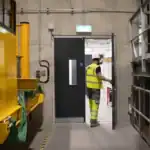Construction worker entering industrial building doorway