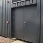 Grey metal security door on industrial building exterior